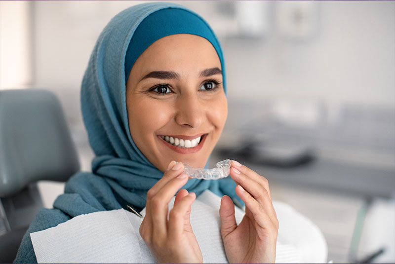 patient putting on their Invisalign within the dental center