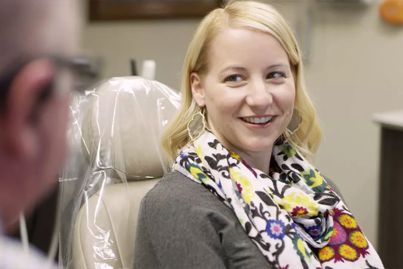 patient smiling brightly while inside of the dental center