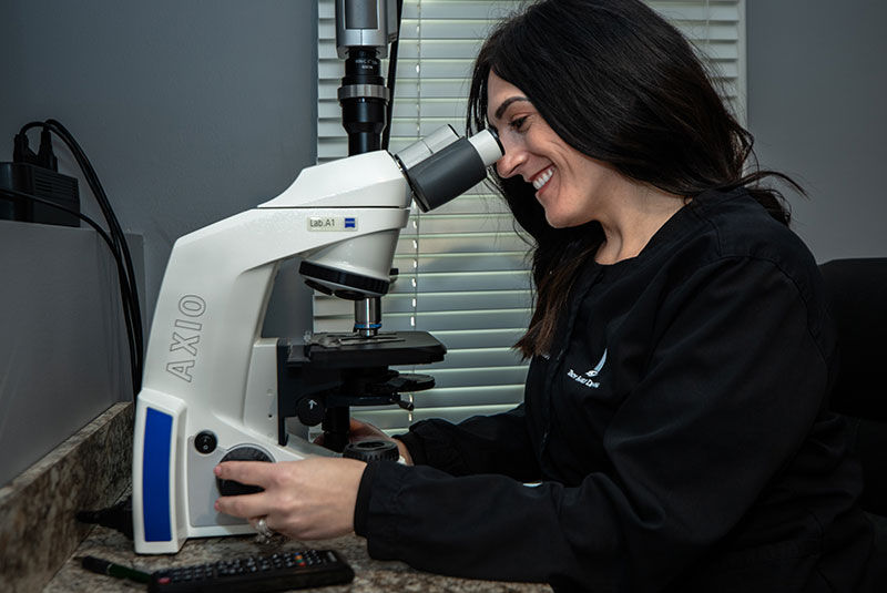 staff member using dental microscope for dental treatment