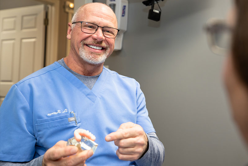 doctor showing patient dental implant full arch