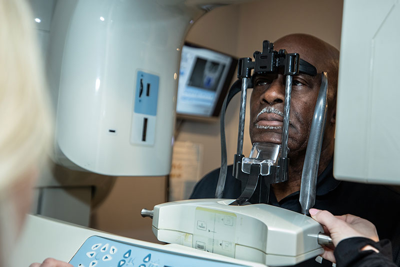 patient undergoing dental scan with device for dental treatment