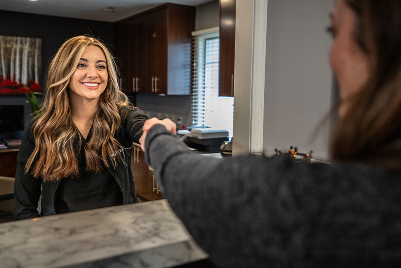 staff member helping patient at the front desk of the dental center